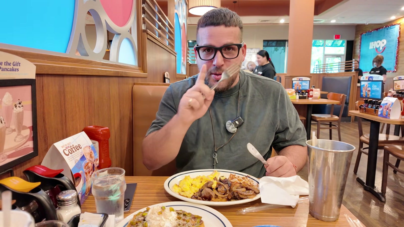 Gerardo en un reservado de IHOP, con el sirloin con huevo revuelto y hash browns servido delante.